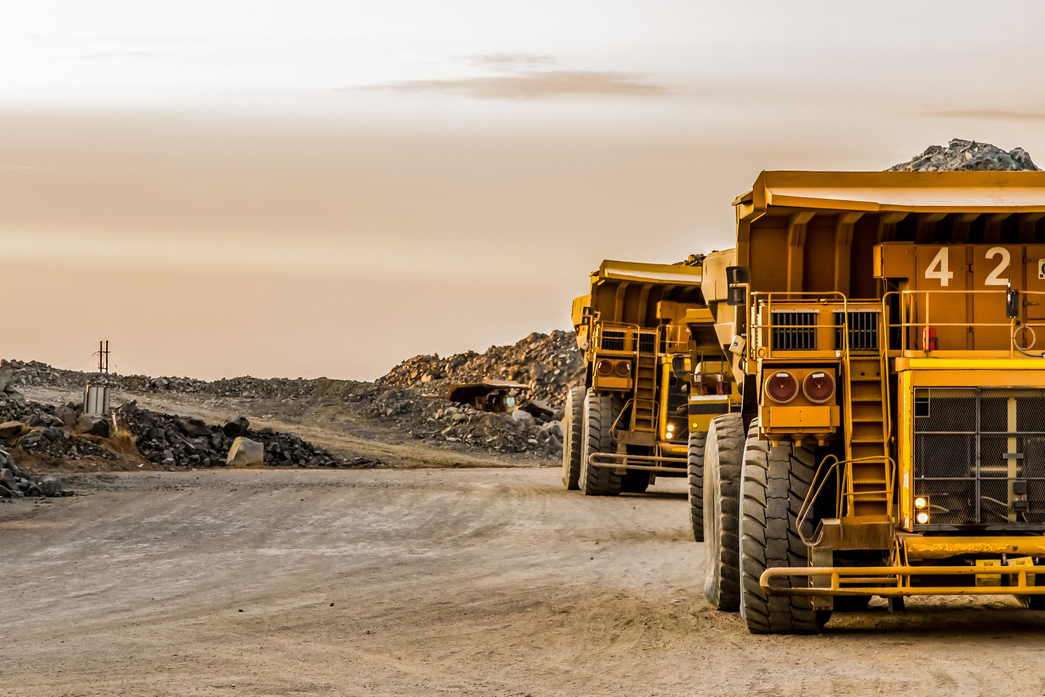 Haul trucks moving material at a mine site
